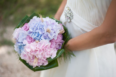 Midsection of woman holding flower bouquet