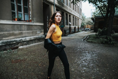 Full length portrait of young woman on walkway in city