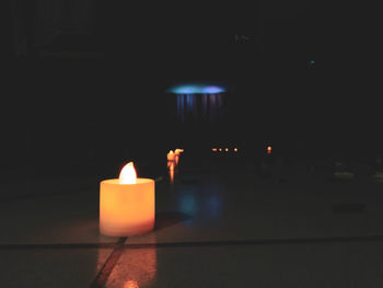 Close-up of lit candles in darkroom