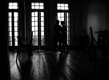 Silhouette people standing on hardwood floor at home