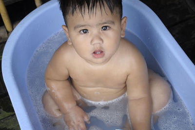 Portrait of cute baby boy in bathtub