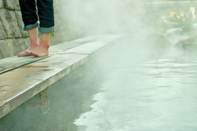 Low section of man standing in water