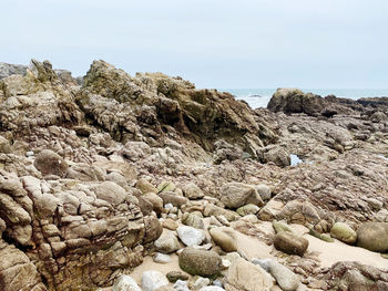 Scenic view of rocks on beach against clear sky