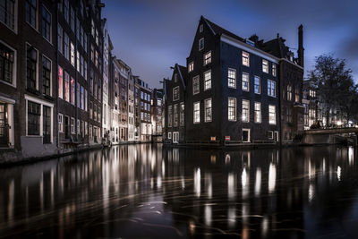Reflection of illuminated buildings in river at dusk