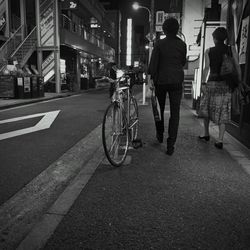 Man riding bicycle on road at night
