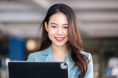 Portrait of young woman using mobile phone