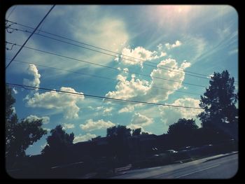 Power lines against cloudy sky