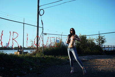 Full length of shirtless woman standing outdoors