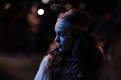 Close-up of girl looking away at night