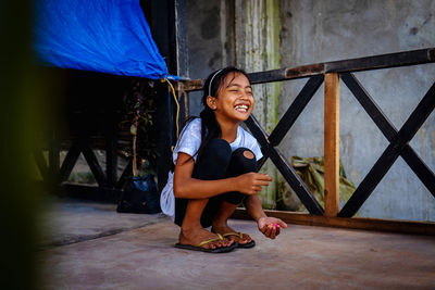 Portrait of smiling boy sitting outdoors