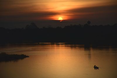 Scenic view of lake against orange sky