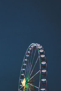 Low angle view of ferris wheel against clear blue sky