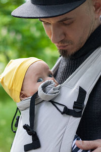 Father carrying his child in a baby sling