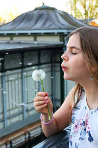 Portrait of a girl holding a dandelion