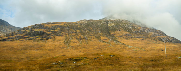 Scenic view of mountains against cloudy sky