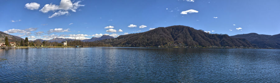 Scenic view of lake by mountains against sky