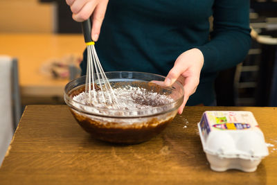 Midsection of woman preparing food at table