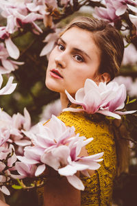 Close-up portrait of woman with pink flowers