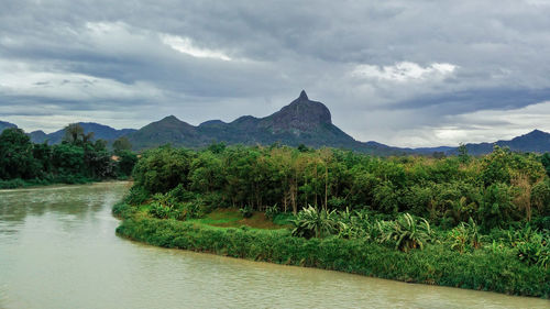 Scenic view of river by mountains against sky