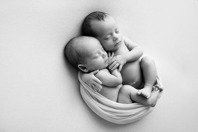 Twin baby boys sleeping on white background