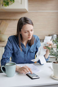 Businesswoman calculating financial bills