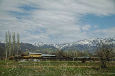 Scenic view of field and mountains against sky
