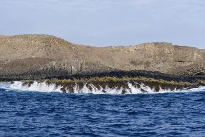 Scenic view of sea and mountains against sky