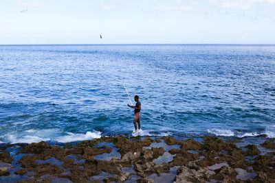 Man standing on beach against sky