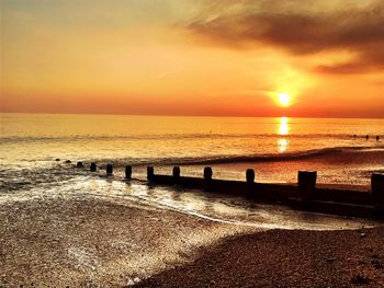 Scenic view of sea against dramatic sky during sunset