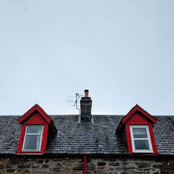 Red house against sky during winter