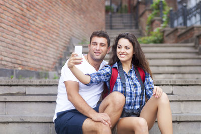 Portrait of young couple sitting outdoors