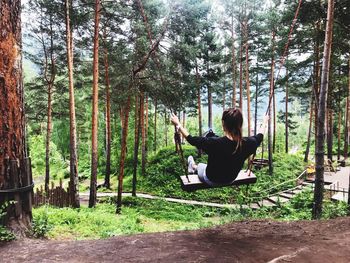 Rear view of woman sitting on swing