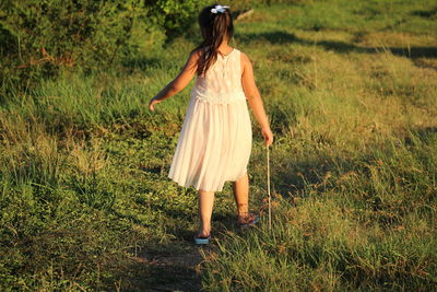 Rear view of girl walking on land 