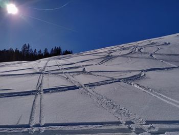 Snow covered landscape against blue sky