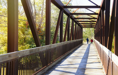 Rear view of man walking on footbridge