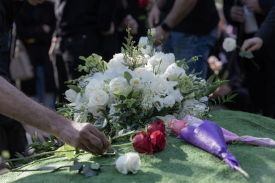 Man placing a flower as a final goodbye over a burial ground