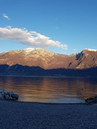 Scenic view of lake and mountains against blue sky
