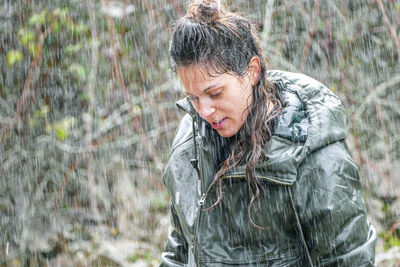 Woman looking away while standing in rain