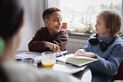 Two boys doing homework at dining table