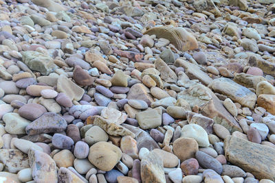 Close up of rounded and polished beach rocks on the sea shore