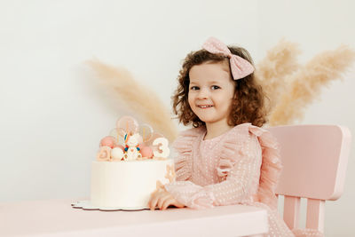 Portrait of a charming little girl with a cake during a birthday celebration