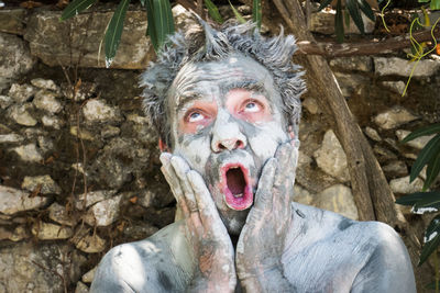 Shocked man with facial mask on face looking up