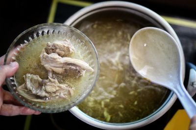 Close-up of hand holding soup in bowl