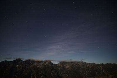 Scenic view of mountains against sky at night