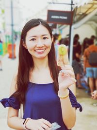 Portrait of a smiling young woman holding ice cream