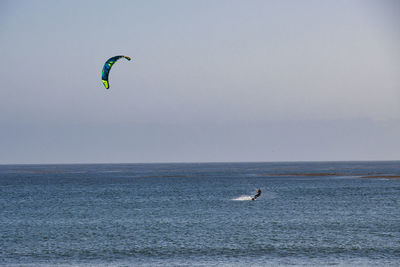 People in sea against sky