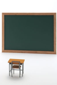 Close-up of toy bench and green board on white background