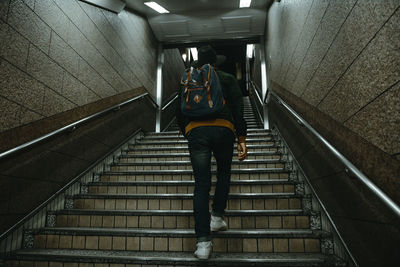 Low angle view of man moving up on staircase at subway station