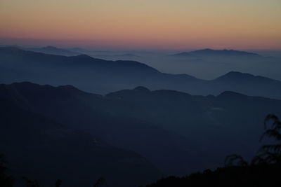 Scenic view of silhouette mountains against sky at sunset