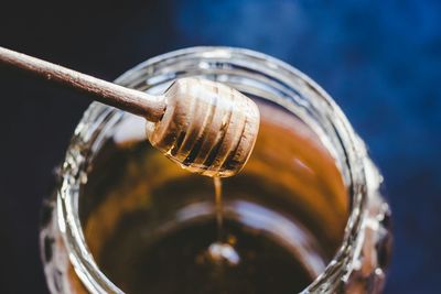 Close-up of honey with dipper over jar